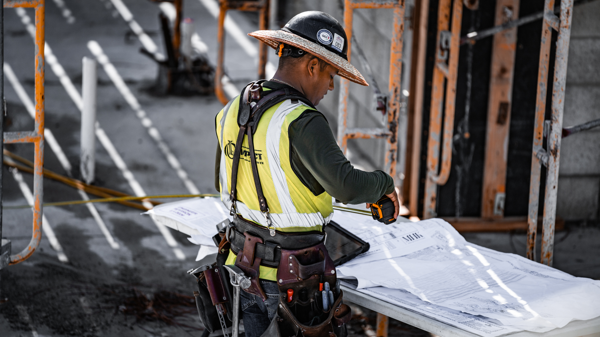 Impact Concrete team member reviewing plans and measurements on site